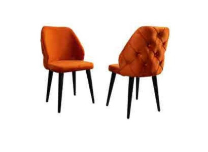 Upholstered wooden chair orange Chesterfield on black legs in the dining room